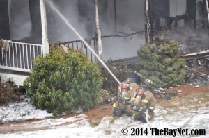 Senior Tristen Plant helping extinguish a house fire. Used by permission of TheBayNet.com.